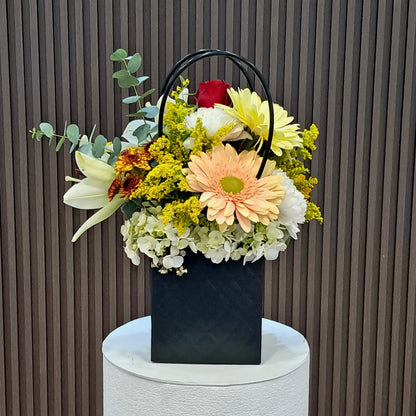 Vista lateral de Primavera de Gala con gerbera, lirios y pomas, disponible en Velve Floristería, Paseo de las Flores.
