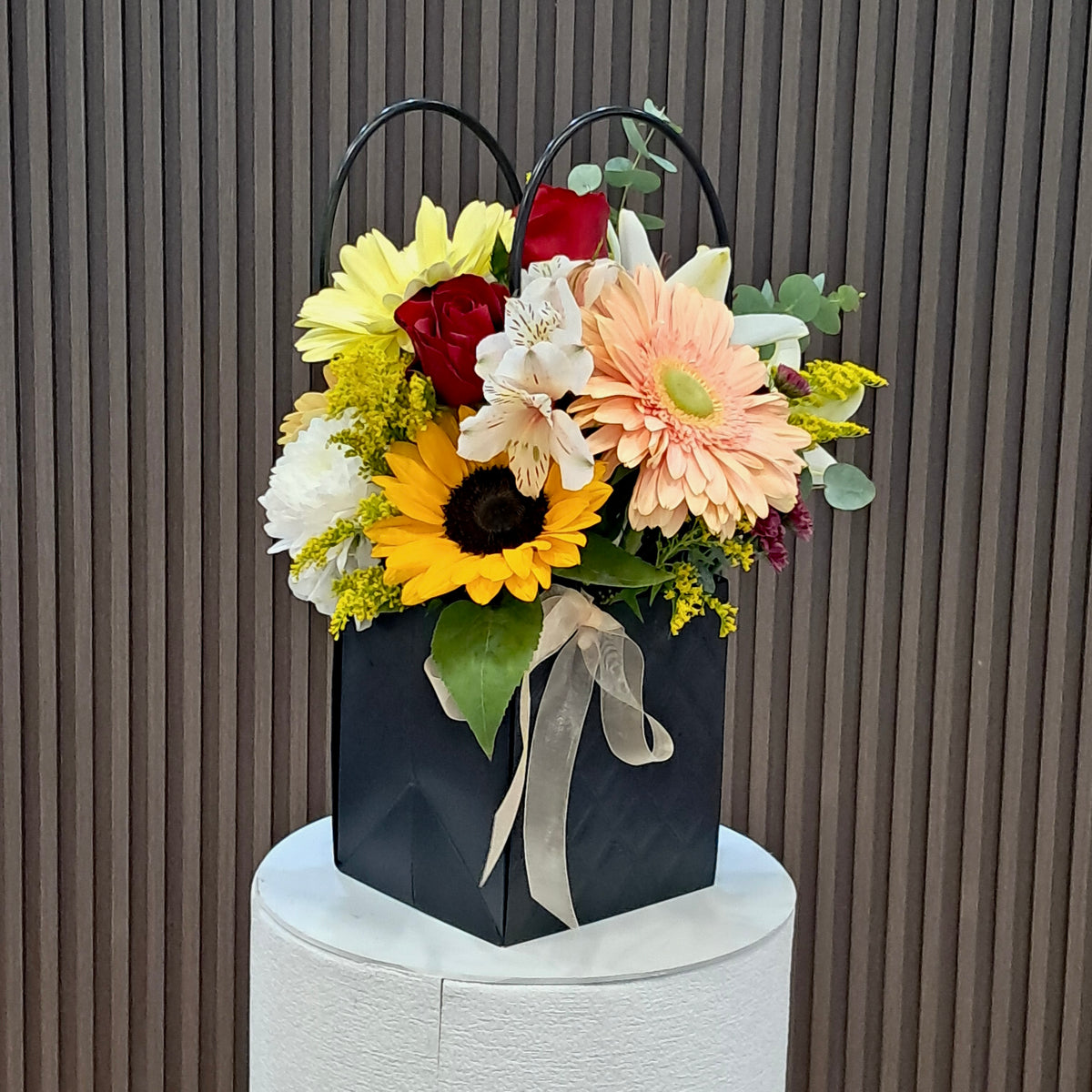 Vista posterior de cartera floral con gerbera, lirio, hortensia y eucalipto de Velve Floristería en Heredia.