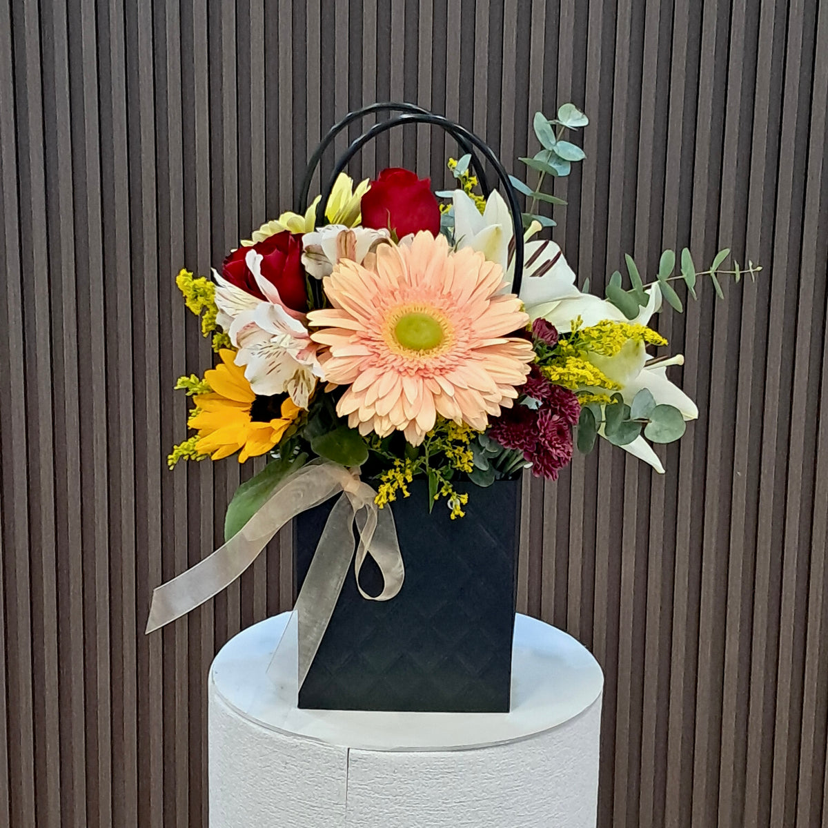 Cartera floral Primavera de Gala con rosas, gerberas, girasol y lirios de Velve Floristería, Paseo de las Flores, Heredia.