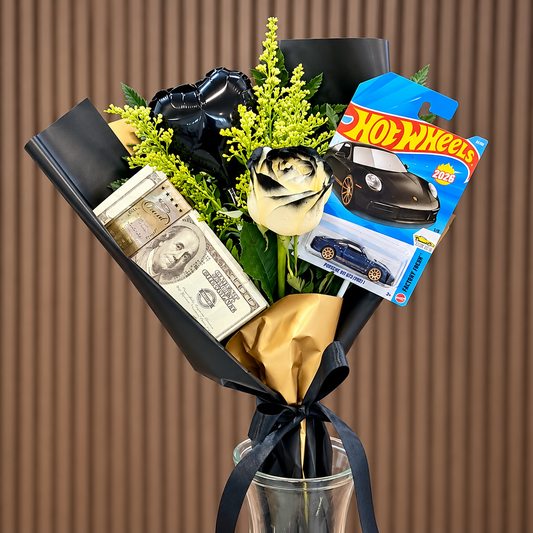 arreglo en envoltura negra y dorada conrosa crema tenida de negro carrito hot wheels y detalle de billete velve floristeria paseo de las flores heredia