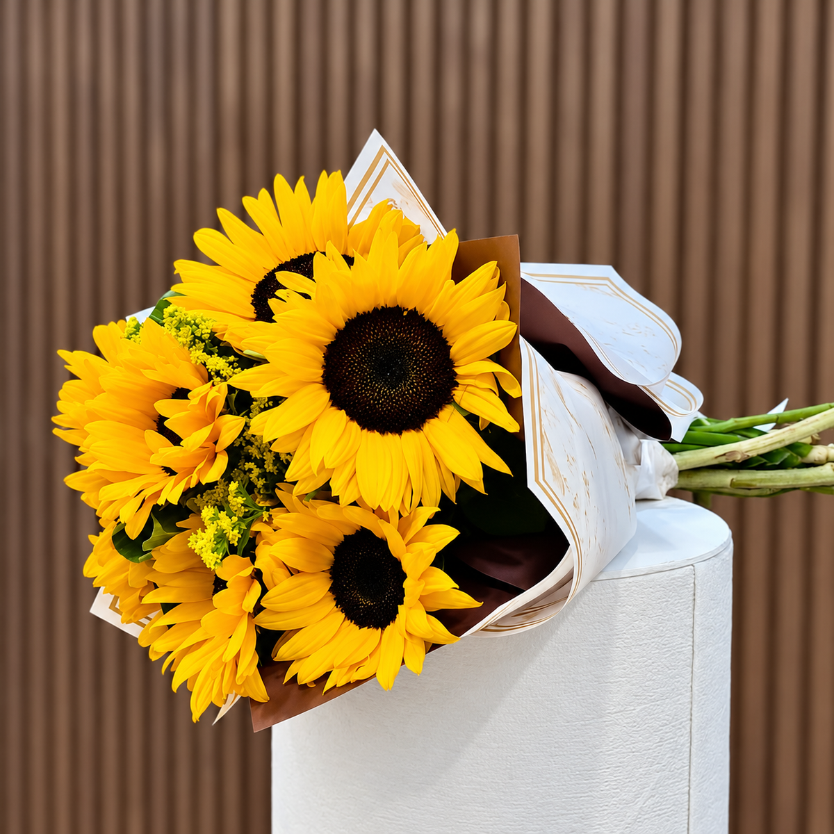 Ramo de girasoles en envoltura blanca y dorada, vista diagonal. Velve Floristería, Paseo de las Flores, Heredia.
