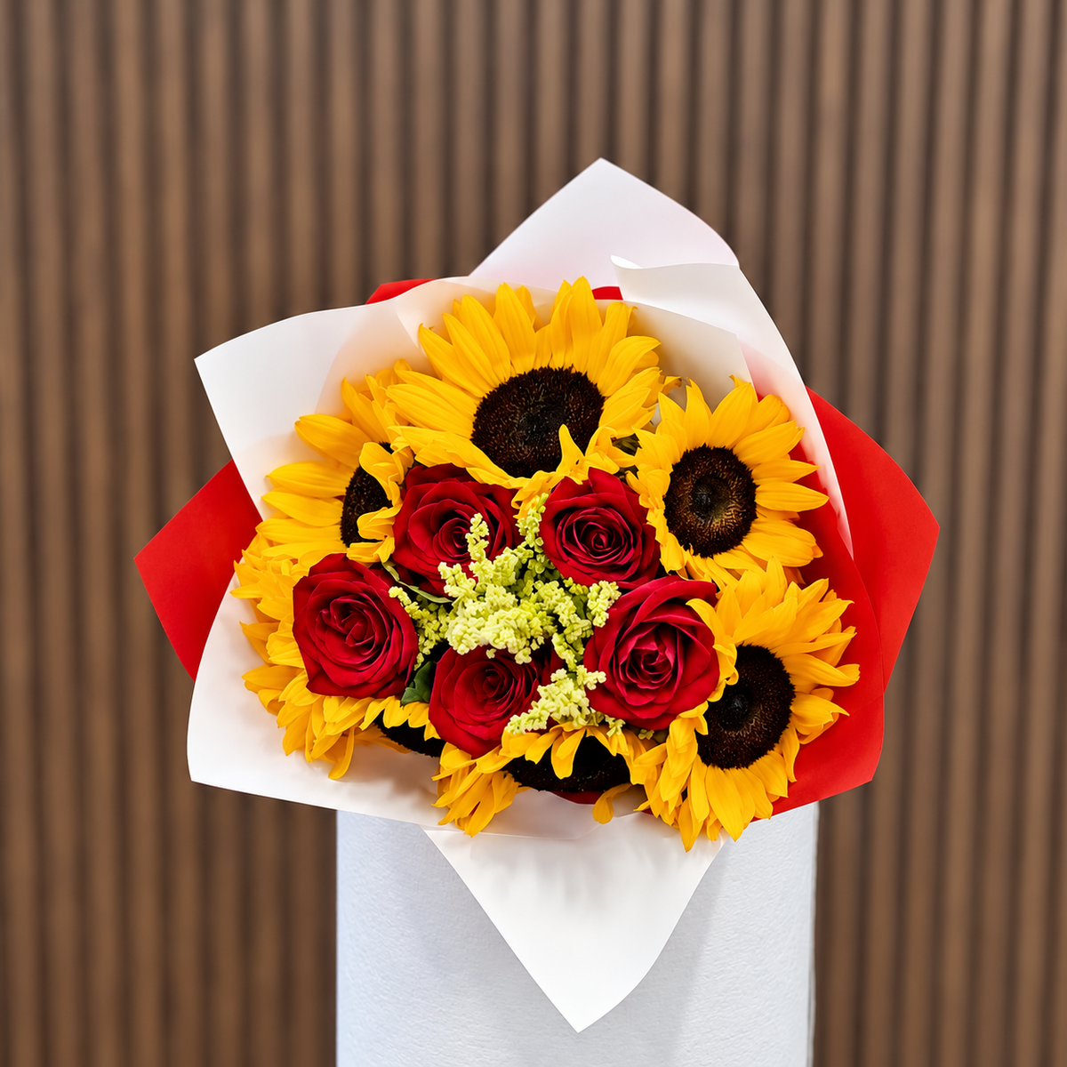 Ramo de girasoles y rosas rojas en envoltura blanca y roja, vista frontal. Velve Floristería, Paseo de las Flores, Heredia.