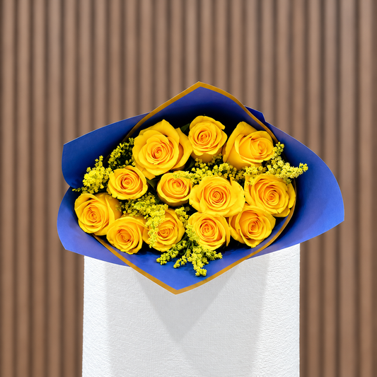 Ramo de rosas amarillas y solidago en envoltura azul y dorada. Velve Floristería, Paseo de las Flores, Heredia.